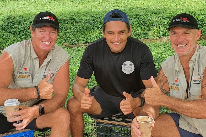 Three sitting men giving thumbs up