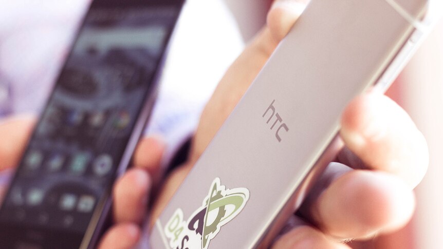 A thin, metallic HTC secured by D4 smartphone, close up.