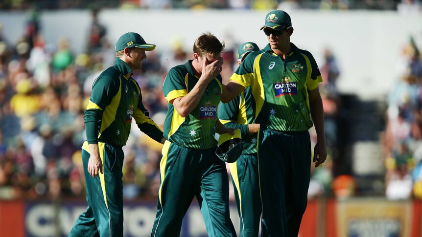 James Faulkner of Australia is consoled by teammates as he leaves the field injured