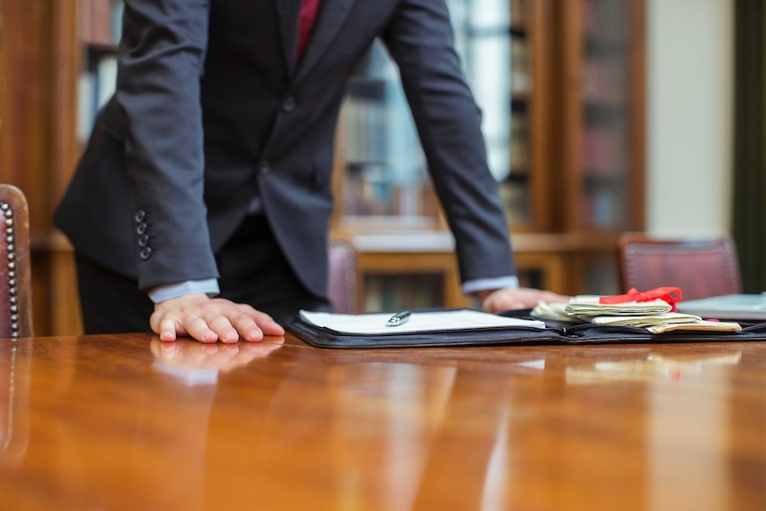 Man standing over desk.