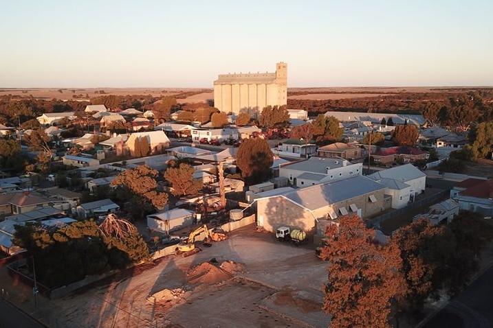 An aerial shot of a country town with a low sun behind it.