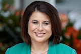 A portrait shot of a smiling woman with dark hair.