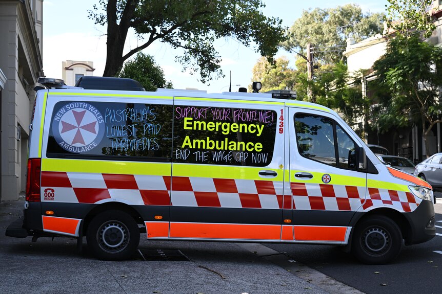 an ambulance with messages written on the side reading australias lowest paid paramedics