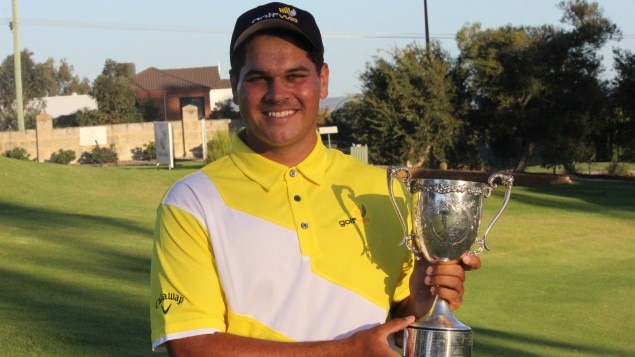 Young golfer holding trophy