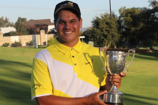 Young golfer holding trophy