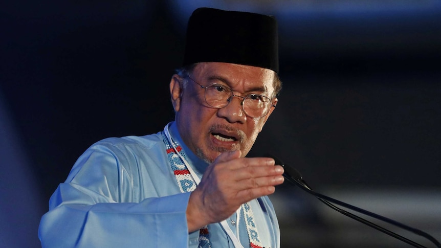 Anwar Ibrahim gestures as he gives a speech.