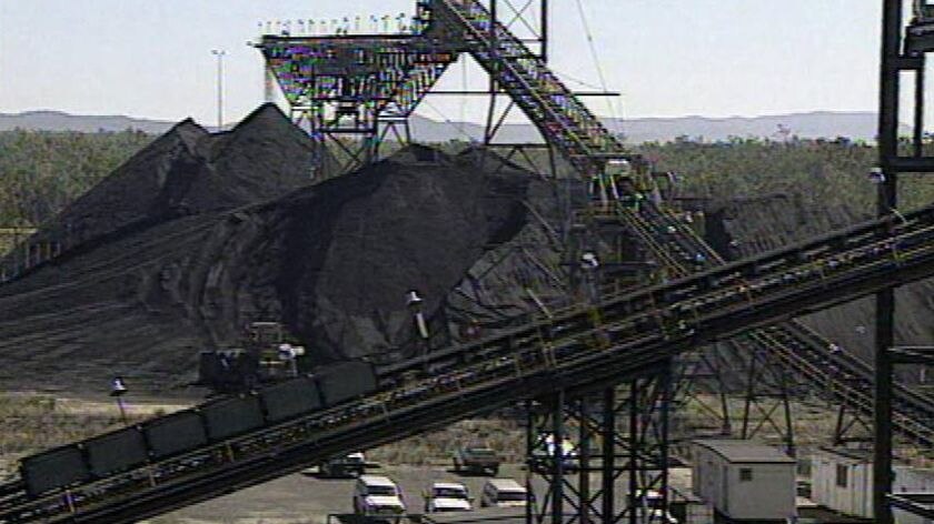 Coal mining site with conveyor belts and excavator equipment.