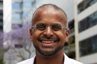 A smiling man wearing glasses.