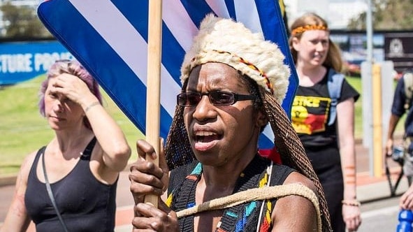 A woman in a street march waves a morning star flag for west papuan independence 