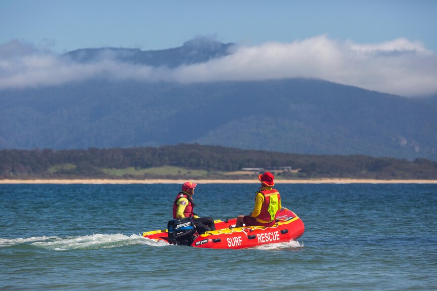 Surf life savers on an inflatable boat at sea.