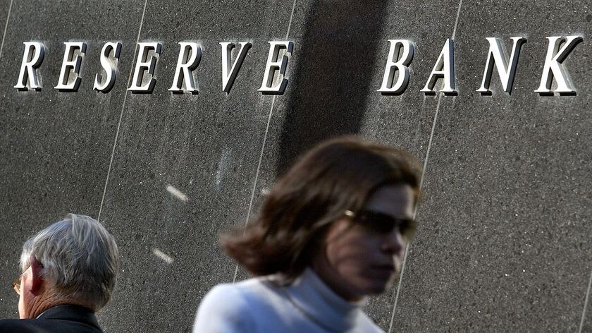 A woman walks past the Reserve Bank of Australia in Central Sydney