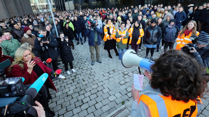 A woman holds a megaphone and speaks to hundreds of Google employees outside the company's Dublin office