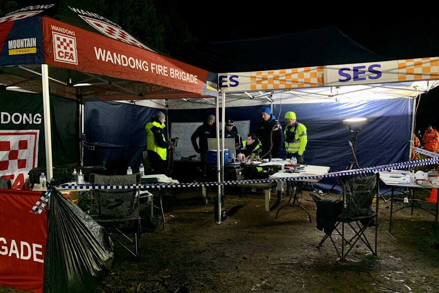 Two emergency services tents with men in warm clothes and high vis gear.