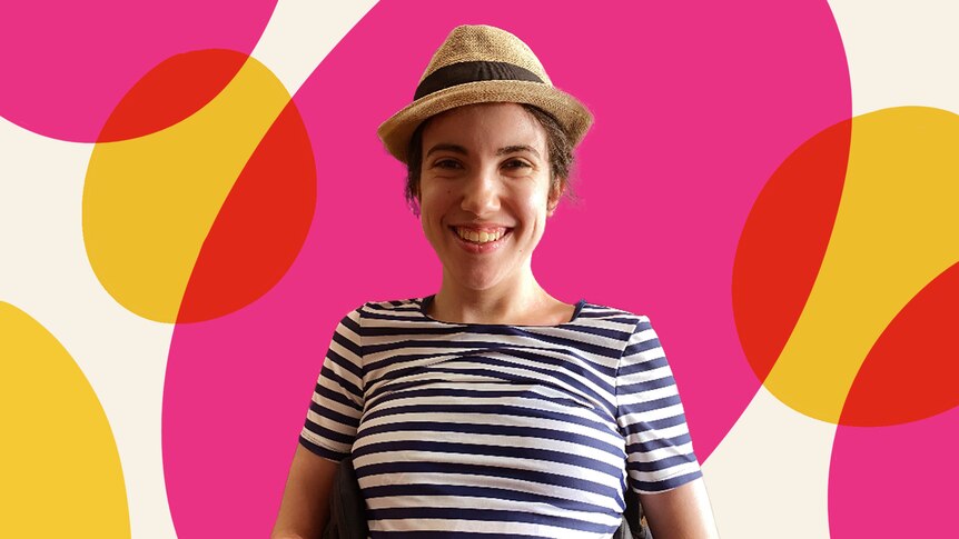 Hannah Diviney wearing a hat and smiling, with a bright pink background.
