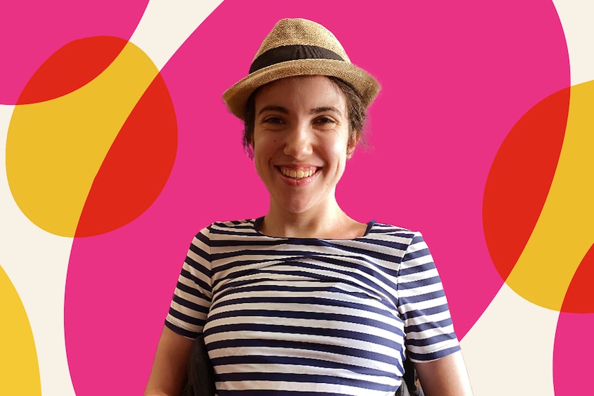 Hannah Diviney wearing a hat and smiling, with a bright pink background.