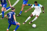 England's Marcus Rashford controls the ball under pressure from three United States players