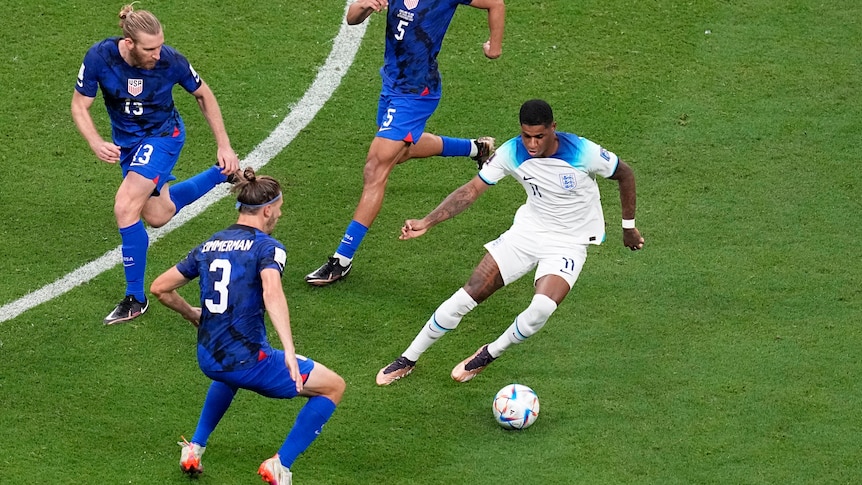 England's Marcus Rashford controls the ball under pressure from three United States players