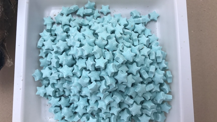 a tub containing star-shaped blue MDMA pills
