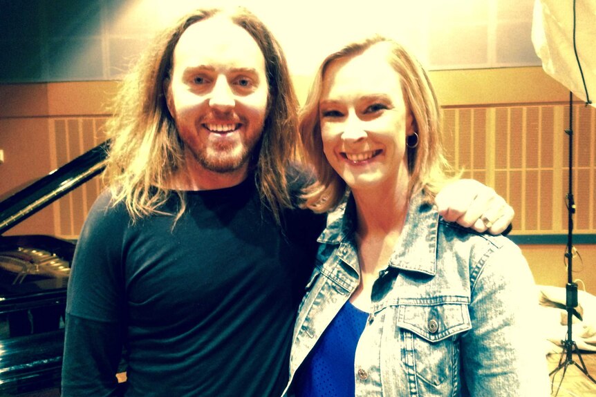 Tim Minchin and Leigh Sales embrace for a photo in what looks to be a recording studio.