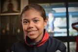 A young Aboriginal girl smiles.