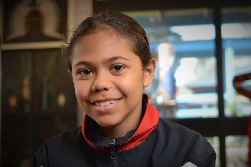 A young Aboriginal girl smiles.