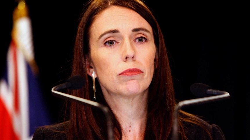 Jacinda Ardern's face is mostly expressionless as she listens to a question.