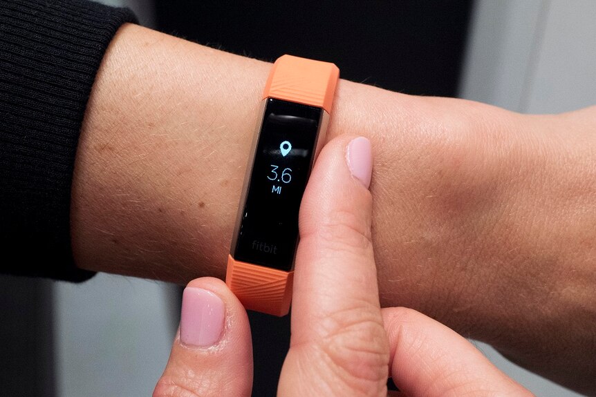 A close up of a Fitbit device on someone's wrist.