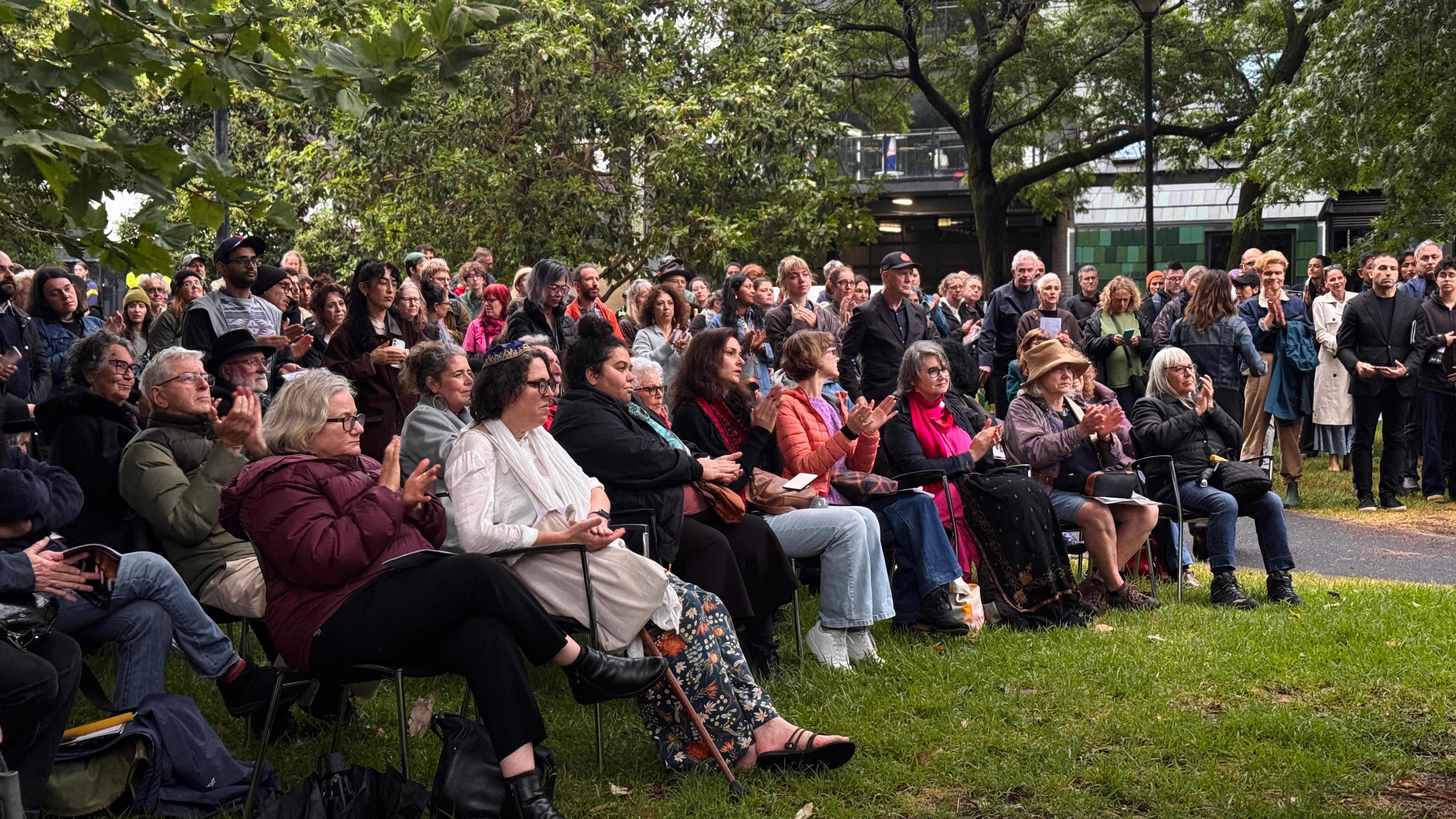 As pessoas no parque sentaram-se em cadeiras.