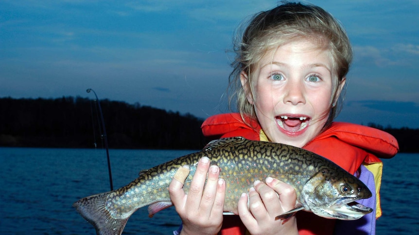 A young girl with a freshly caught fish