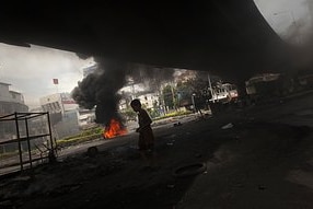 A boy walks under an overpass in Ding Daeng, near Bangkok's Victory Monument, where anti-government Red shirt supporters left...