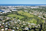 An aerial view showing farmland and all of the development around it with the ocean in the background.