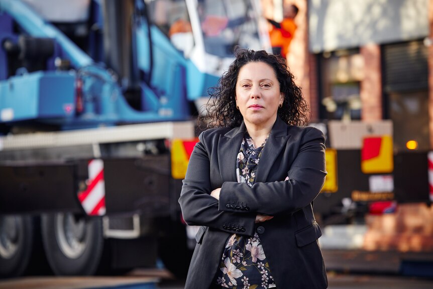 A woman stands infront of trucks 