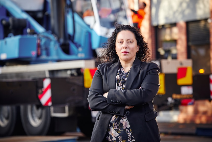A woman stands infront of trucks 
