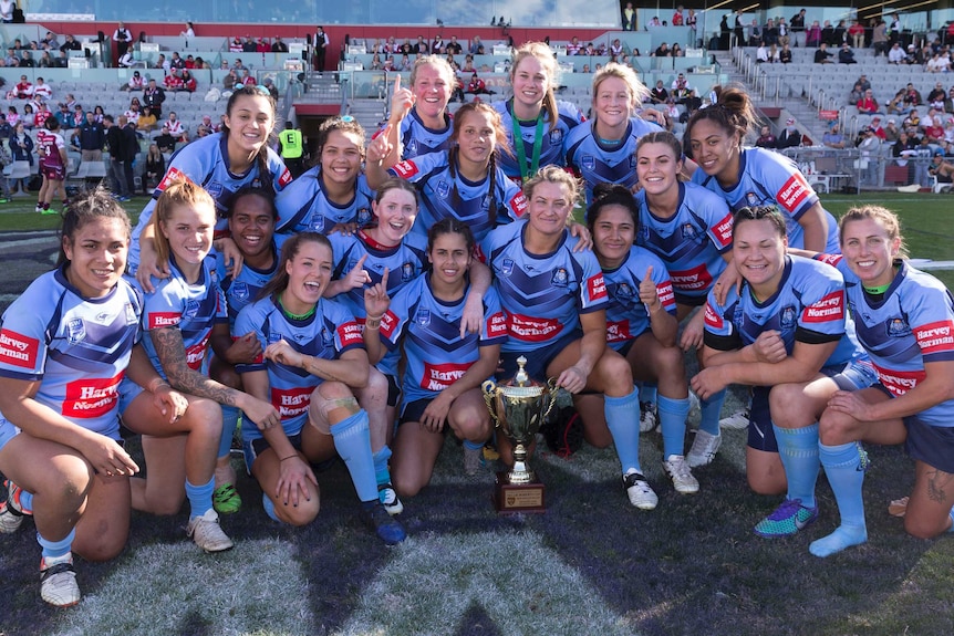 New South Wales players celebrate around the trophy after beating Queensland in the Interstate Challenge.