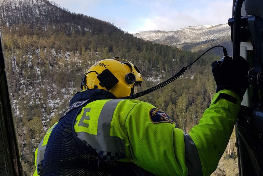 Police officer looks out from a search and rescue helicopter