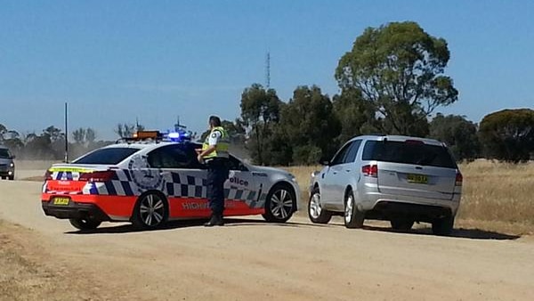 Police cars at Old Deniliquin Road, north of Moama where two people were found dead