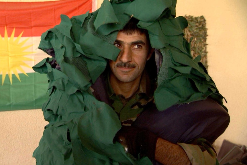 A soldier wears a camouflage suit