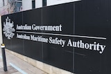 A black sign on a concrete wall that reads 'Australian Government. Australian Maritime Safety Authority'.
