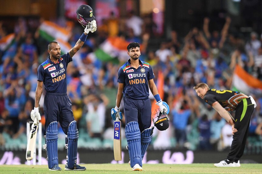 Two India male batters celebrate beating Australia in a T20 international in Sydney.