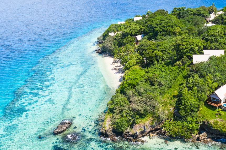 Image de drone de l'île et des eaux turquoises.