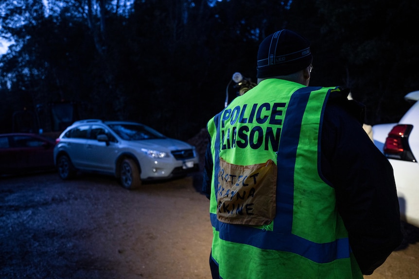 A police officer standing in hi-vis vest.