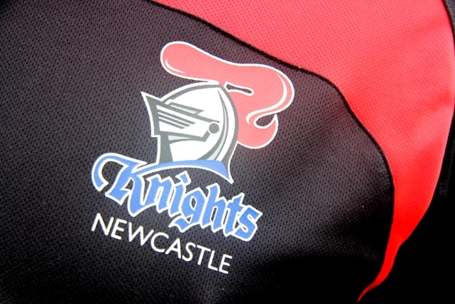 The Newcastle Knights logo, depicting a plumed jousting helmet, emblazoned on a jersey.