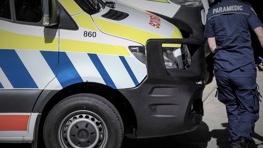 Unidentified Ambulance Tasmania female paramedic near an ambulance