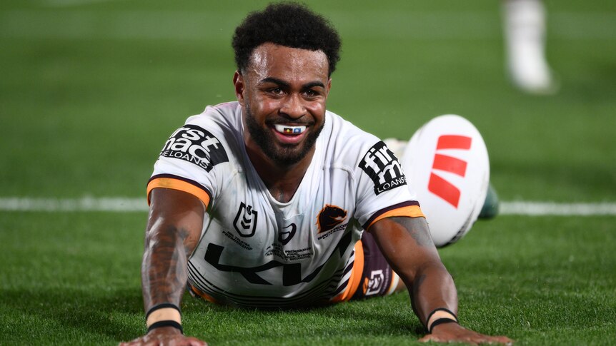 A Brisbane Broncos NRL player scores a try in the grand final.