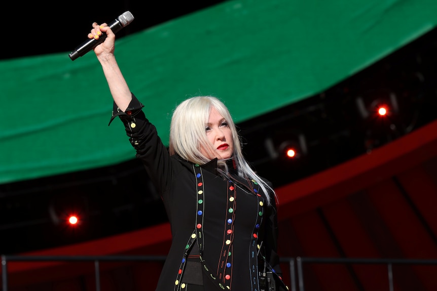 Cyndi Lauper holds up a microphone on stage at the Global Citizen Live concert