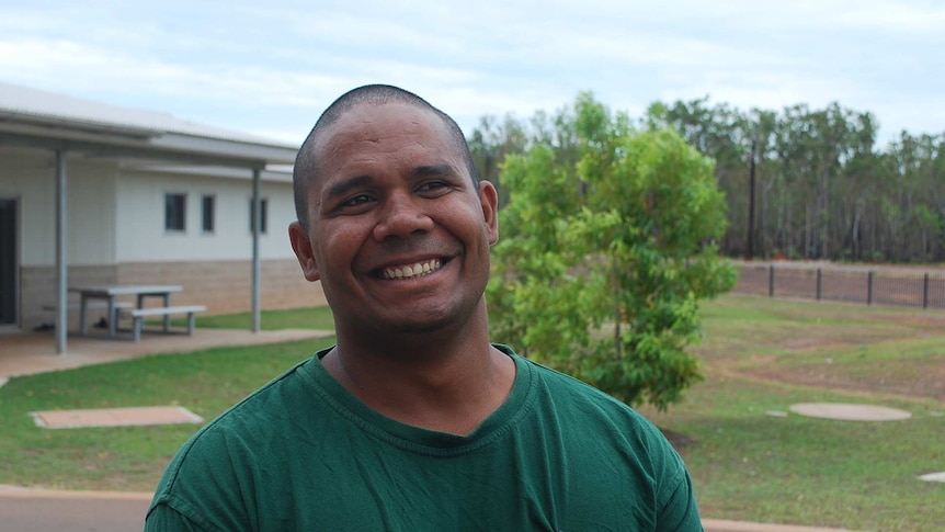A portrait of Kevin Tomlins smiling, on prison grounds.