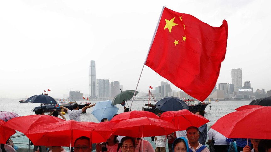 Pro-China supporters hold red umbrellas during a counter-rally in support of Hong Kong police