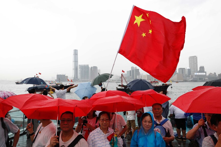 Pro-China supporters hold red umbrellas during a counter-rally in support of Hong Kong police