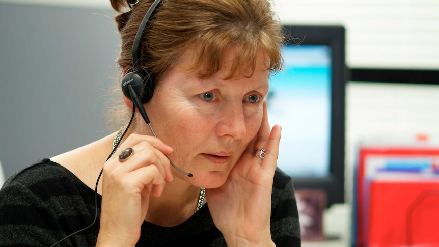 close up of woman sitting at desk with headset on talking into speaker