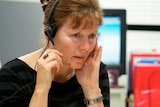 close up of woman sitting at desk with headset on talking into speaker